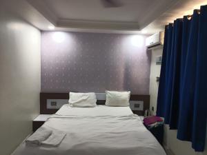 a bedroom with a bed and a blue wall at Hotel Naman in Patna