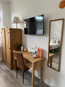 a room with a desk and a mirror and a bed at Pension in Delmenhorst in Delmenhorst +14 photos