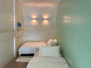 a small bedroom with two beds and lights on the wall at Village 40 Phuket Old Town in Phuket +59 photos