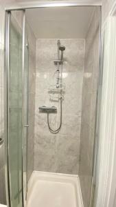 a shower with a glass door in a bathroom at Spacious 1 Bedroom near central London Kings Cross walking to Arnos Grove Tube, Alexandra Palace, Euston in New Southgate +7 photos