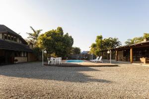 um pátio com cadeiras brancas e uma pequena piscina em Chácara com lareira e fogão a lenha em Pirabeiraba em Joinville