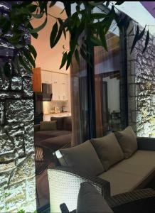 a living room with a couch and a stone wall at Terracotta Villa in Himare