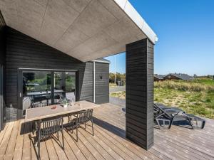 a wooden deck with a table and chairs on it at Holiday Home Chenoa - 350m from the sea by Interhome in Ringkøbing