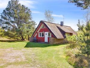 a red house with a thatched roof on a field at Holiday Home Efimija - 1-4km from the sea by Interhome in Mølby