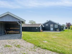 a couple of barns with a grass yard at Holiday Home Guthmund - 400m from the sea by Interhome in Otterup