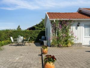 Un patio con dos macetas de flores al lado de un edificio. en Holiday Home Mikkeline - 575m to the inlet by Interhome, en Holbæk