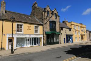 una strada con edifici sul lato della strada di Centre Of Britain Hotel a Haltwhistle