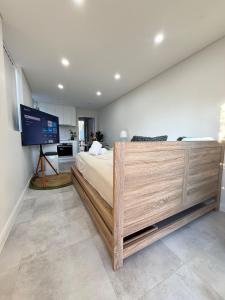 a bedroom with a large bed and a flat screen tv at Fully equipped brand new built studio in Chipping Norton