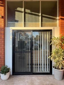 an entry door to a house with plants at Fully equipped brand new built studio in Chipping Norton