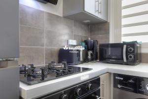 a kitchen with a stove and a microwave at Mosala 4 - T3 pieds dans l'eau à Saint-Leu in Saint-Leu
