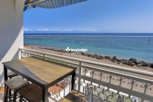 a table on a balcony with a view of the beach at Mosala 4 - T3 pieds dans l'eau à Saint-Leu in Saint-Leu