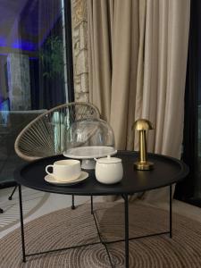 a black coffee table with cups and plates on it at Terracotta Villa in Himare +30 photos