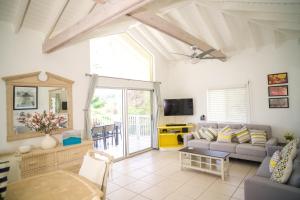 a living room with a couch and a tv at Antigua Bay Villa in Bats Cave