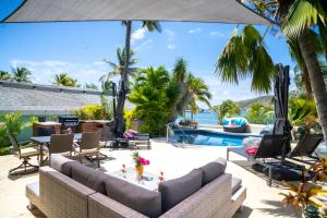 an outdoor patio with couches and a swimming pool at Antigua Bay Villa in Bats Cave