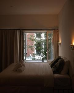 ein Schlafzimmer mit einem Bett und einem großen Fenster in der Unterkunft Studio Nolo by Simone Antwerp in Antwerpen