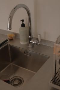 eine Spüle mit einem Wasserhahn und einem Waschbecken in der Unterkunft Studio Nolo by Simone Antwerp in Antwerpen