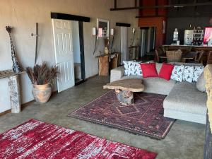 a living room with a couch and a table at Big Cats Namibia Farmstay & Tours in Outjo +76 photos
