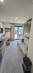 a living room with a couch and a kitchen at L'Aiguillon - Studio avec Jacuzzi pour 2 personnes et enfants proche stations - Idéal couple avec 1 enfant in Saint-Jean-de-Sixt