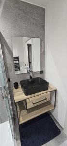 a bathroom with a black sink and a mirror at L'Aiguillon - Studio avec Jacuzzi pour 2 personnes et enfants proche stations - Idéal couple avec 1 enfant in Saint-Jean-de-Sixt