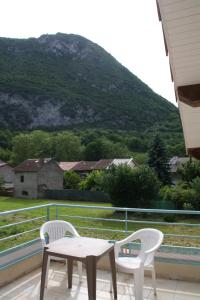 a table and two chairs on a balcony with a mountain at La petite auberge de niaux in Niaux