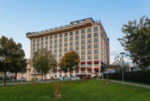 Un gran edificio con un parque enfrente. en Almira Hotel Thermal Spa & Convention Center, en Bursa