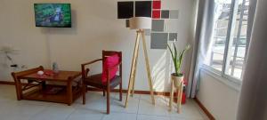 a living room with a table and a chair and a lamp at Mendoza departamento in Guaymallen