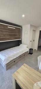 a room with two beds and a table at L'Aiguillon - Studio avec Jacuzzi pour 2 personnes et enfants proche stations - Idéal couple avec 1 enfant in Saint-Jean-de-Sixt