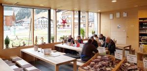 a group of people sitting at tables in a store at Wäldermetzge Hüttenzimmer und Wohnungen in Warth am Arlberg