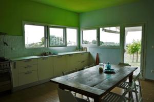 a kitchen with a wooden table with chairs and windows at Sea Sight Greece in Angelochórion