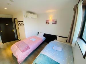 a room with two beds in a room at Omori Happy Smile Hotel-Self Check In in Tokyo