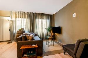 a living room with a couch and a chair at Wieler Wellness Huuske with private sauna in Spaubeek +31 photos