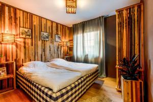 a bedroom with a bed and a wooden wall at Wieler Wellness Huuske with private sauna in Spaubeek