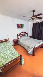 a bedroom with two beds and a ceiling fan at La Cañada in Rafaela +2 photos