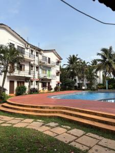 a swimming pool in front of a building at M R Holidays Apartments in Arpora