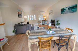 a living room with a large wooden table and chairs at Coastal Garden Villa in Albany
