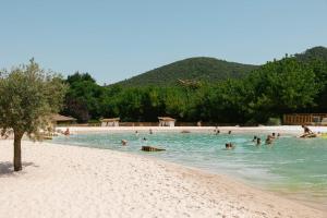 a group of people swimming in the water on a beach at Slow Village Anduze - Cévennes in Corbés
