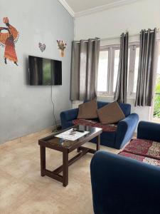 a living room with a couch and a coffee table at M R Holidays Apartments in Arpora
