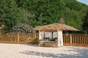 a gazebo with a couch in front of a fence at Slow Village Anduze - Cévennes in Corbés