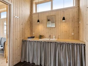 ein Badezimmer mit einem Duschvorhang über einem Waschbecken in der Unterkunft Holiday Home Skamhals - 440m to the inlet by Interhome in Frederiksværk + 15 Fotos