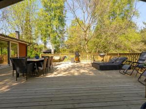eine Terrasse mit Tisch und Stühlen auf einem Deck in der Unterkunft Holiday Home Ulfiat - 2km from the sea by Interhome in Ebeltoft