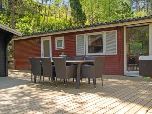 eine Terrasse mit Tisch und Stühlen auf einem Deck in der Unterkunft Holiday Home Ulfiat - 2km from the sea by Interhome in Ebeltoft