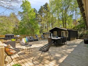 eine Terrasse mit einem Tisch und Stühlen sowie ein Haus in der Unterkunft Holiday Home Ulfiat - 2km from the sea by Interhome in Ebeltoft + 16 Fotos