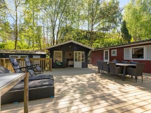 eine Terrasse mit einem Tisch und Stühlen sowie ein Haus in der Unterkunft Holiday Home Ulfiat - 2km from the sea by Interhome in Ebeltoft