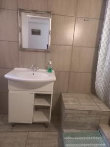 une salle de bain avec un lavabo et un miroir dans l'établissement Ormonde guesthouse, à Pretoria 13 autres photos
