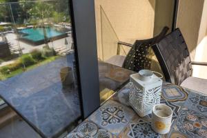 - une table en verre avec deux tasses sur le balcon dans l'établissement Artistic space in Azur Premium, à Varna