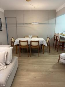 a dining room with a white table and chairs at Apartamento espaçoso Praia Brava in Itajaí