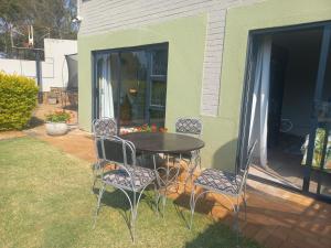 un patio avec une table et des chaises sur un porche dans l'établissement Ormonde guesthouse, à Pretoria