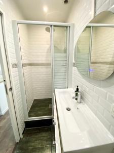 a white bathroom with a sink and a shower at Maison le Bac Apartments in Paris
