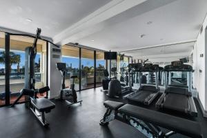 a gym with treadmills and elliptical machines and windows at Crowne Plaza Perth by IHG in Perth