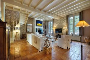 a living room with white furniture and a brick wall at Fripouille - A 100 m de la plage in Royan